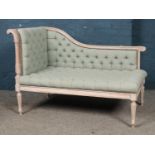 A French chalked corner sofa/chaise lounge of small proportion, with heavily carved detailing and