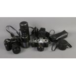 A collection of cameras and accessories including Canon EOS-1000, Fujica STX-1N, lens and flash.