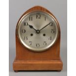 A mahogany mantle clock, with Arabic numeral dial raised on four small turned feet. 31cm high. key