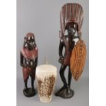 Two carved hardwood African figures along with an animal hide drum. Tallest figure 66cm tall.