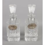 A pair of cut glass decanters bearing silver A. Chick & Sons Ltd labels. Assayed London 1971 and