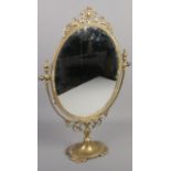 An ornate brass dressing table mirror.