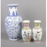 Large oriental style blue and white vase along with two smaller famille rose vases decorated with