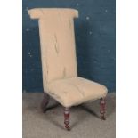 A prayer dieu chair, with turned front feet raised on casters. Scratches to the fabric to one