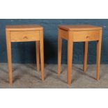 A pair of modern bedside tables featuring soft-close single drawer raised on tapered legs.