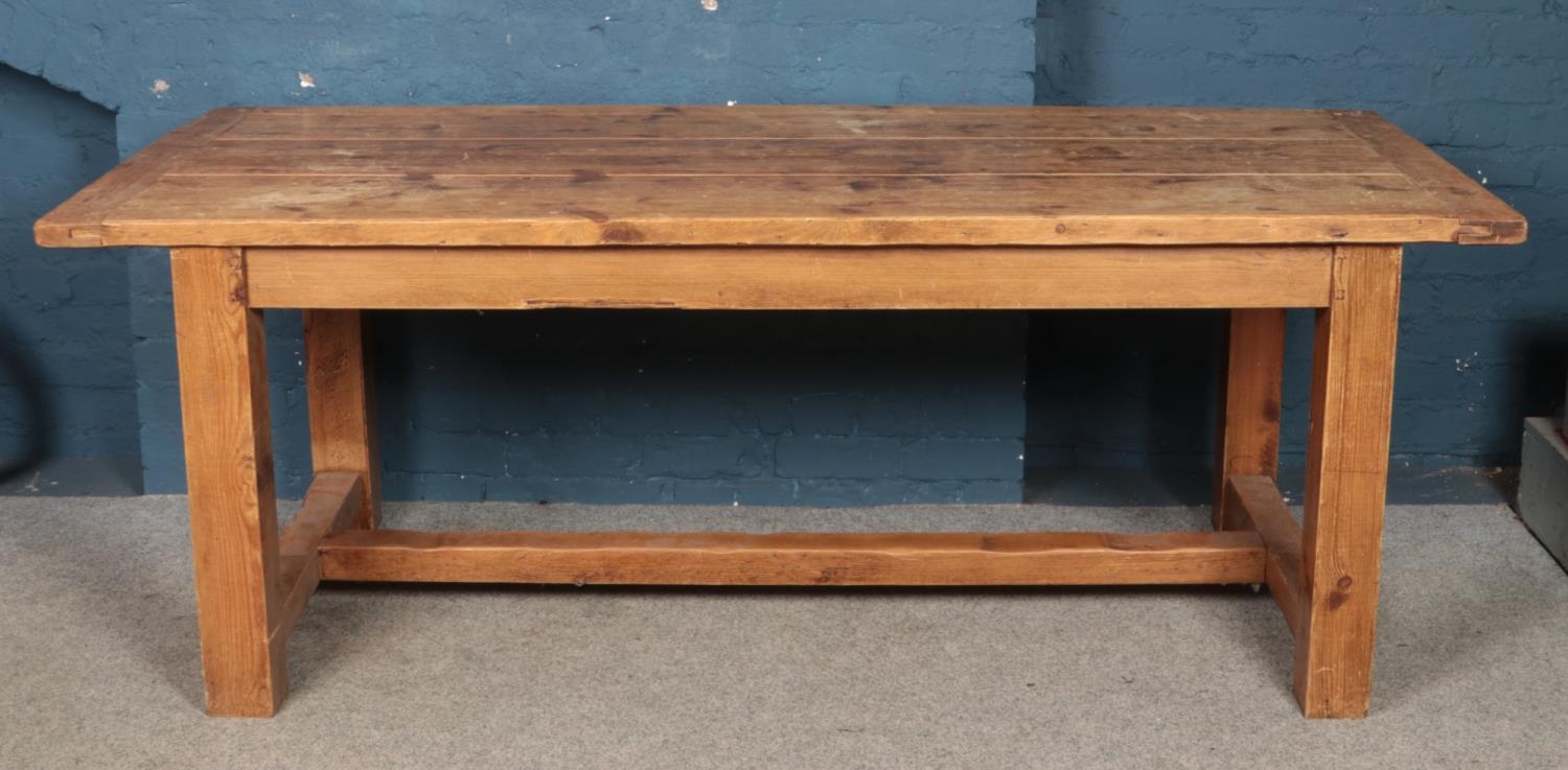 A large pine refectory dining table, with central stretcher. Height: 78cm, Width: 212cm, Depth: