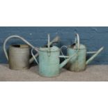 Three galvanised watering cans, one with rose head.