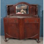 A stained oak mirror back sideboard, with dome top bevel edge mirror. With turned pedestal supports,