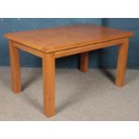 A modern oak veneered dining table. Height: 77cm, Width: 140cm, Depth: 90cm. Chip to the veneered