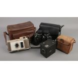Two cameras and a pair of binoculars. Includes Polaroid J33 Land Camera, Kodak Six20 brownie