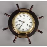 A Schatz bulk head clock in the shape of a ships wheel. With presentation plaque from Officers, US