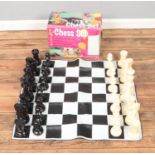 A boxed floor chess set including mat and pieces. Set is complete.