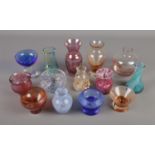 A collection of small coloured glass vases mainly Caithness examples.