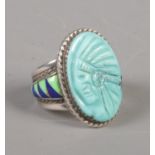 A silver Navajo style ring with carved portrait of a Native American and enamel shoulders. Size T.