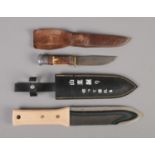 A Johnson Western antler/horn handled knife along with modern Asian knife. Both sheathed.