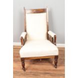 A Victorian mahogany cream upholstered arm chair on castors.