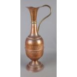 A tall copper water jug featuring hammered detailing.