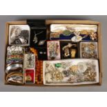 A tray containing an assortment of costume jewellery, including bangles, brooches, beaded