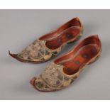 A pair of Eastern leather slippers featuring embroidered decoration.
