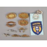 A quantity of military cap badges and pins including the Parachute Regiment and Glider Pilot