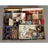 A tray containing an assortment of costume jewellery, including insect brooches, belt buckles,