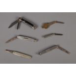 A collection of pocket knives including novelty Farthing example.