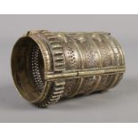 An eastern brass bangle with pierced detailing. 10.5cm long.