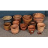 A collection of terracotta planters of varying sizes to include decorative lattice work example.