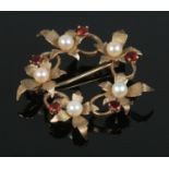 A 9ct Gold Garnet and Pearl brooch in a circular leaf form. Total weight: 4.9g