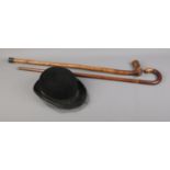 A Herbert Johnson bowler hat with fascinator along with two carved walking sticks.