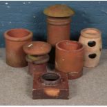 A quantity of chimney pots and planters. Includes terracotta examples, etc.