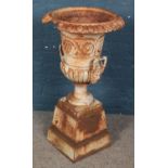 A large cast iron garden urn. With floral decoration and lion mask handles. (89cm x 47cm) Large