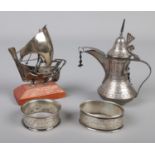 A small collection of silver and white metal. Includes napkin rings, small boat and a miniature