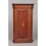 A Georgian oak corner cupboard with shell patera inlaid door. Height 88.5cm, Depth from back