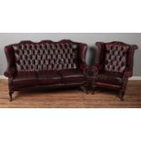 An Oxblood Chesterfield style red wingback chair and matching wingback three seater sofa.