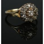 An 18ct gold and diamond cluster ring. Centre stone approximately 0.2ct. Size S. 4.87g. Would
