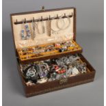 A cantilever jewellery box with contents of costume jewellery including bracelets, rings,