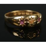 A Victorian 22ct gold three stone ring set with two pink rubies and a seed pearl. Assay marks for