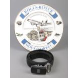 A Rolls Royce commemorative plate along with a leather belt with Rolls Royce buckle.