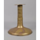 A 17th century brass candlestick with trumpet base and bobbin stem. Height 19.5cm.