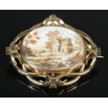 A Victorian gold mourning brooch with oval painted and hairwork panel depicting landscape scene with