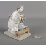 Lladro figurine of a kneeling lady tending to flowers (damaged flowers)
