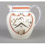 An early 19th century creamware jug featuring various tool motifs and cottage scene, marked