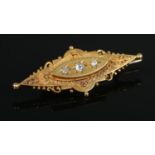 A Victorian 15ct gold and three stone diamond brooch. Having old cut diamonds and locket back. 5cm