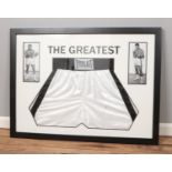A pair of Everlast boxing shorts signed by Muhammed Ali mounted is display frame. Approx. frame