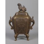 A Chinese bronze censer with cover surmounted by a Foo dog. Having twin elephant mask handles and