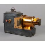 A magic lantern projector stamped The Valor Co. Birmingham converted to electric with storage tin.