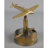 A RAF brass trench art ashtray. Formed as a war plane at the top of a bullet. Baring broad arrow