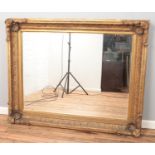 A very large gilt wood framed rococo style bevel edge wall mirror. 121cm x 151cm.