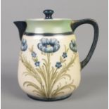 An early 20th century James Macintyre teapot decorated with tube lined blue poppies. Pattern